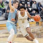 KEITH THORPE/PENINSULA DAILY NEWS Peninsulas Javon Ervin heads for the lane as Whatcoms Noah Madsen, right, impedes his progress on Wednesday in Port Angeles.