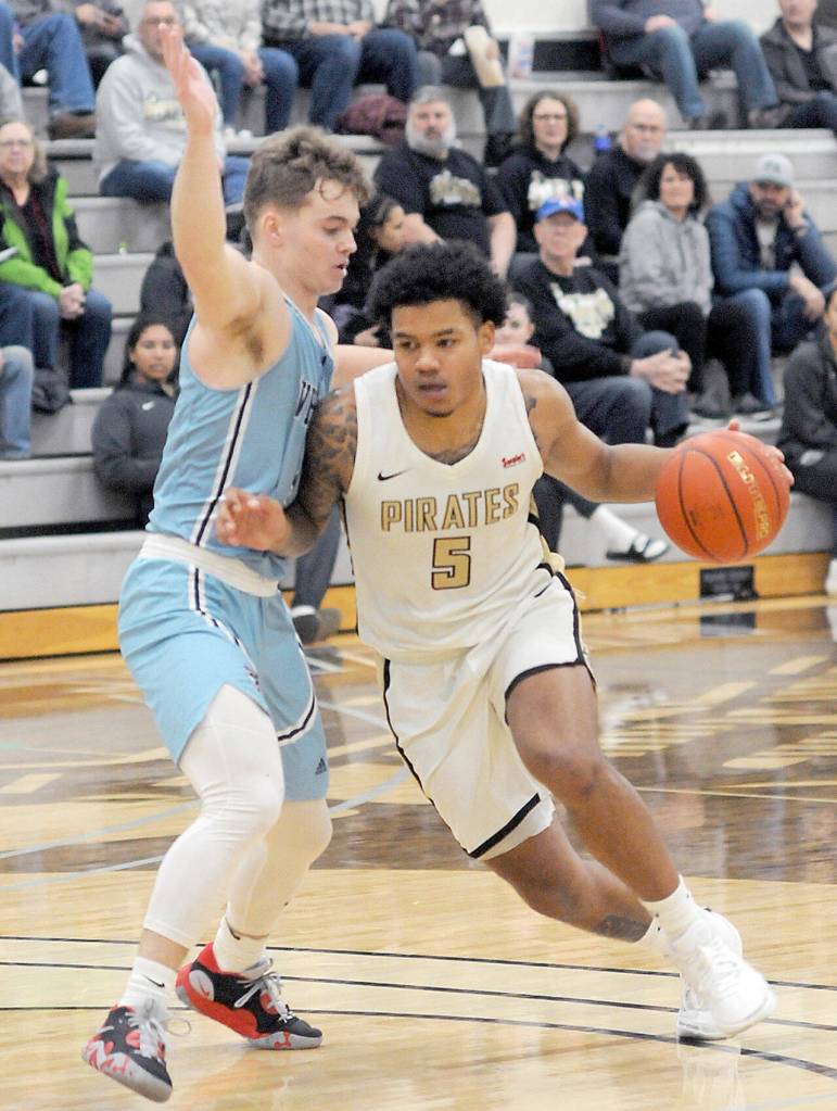 KEITH THORPE/PENINSULA DAILY NEWS Peninsulas Javon Ervin heads for the lane as Whatcoms Noah Madsen, right, impedes his progress on Wednesday in Port Angeles.