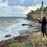 Port Townsends Margo Karler uses her cell phone to photograph wave action at North Beach in Port Townsend on Thursday. (Steve Mullensky/for Peninsula Daily News)