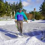 Jeff Mather, from Port Townsend, finishes up shoveling about 4 inches of snow from his driveway on Friday morning after a winter storm passed through late Thursday evening. Mather moved to Port Townsend from Fiji in 2019 and is getting used to the winter conditions in the Pacific Northwest. (STEVE MULLENSKY/FOR PENINSULA DAILY NEWS)