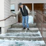 Darryl Wood of Port Angeles makes his way down icy steps at Bethany Pentecostal Church in Port Angeles after shoveling snow and spreading an ice-melting agent on Friday morning. (KEITH THORPE/PENINSULA DAILY NEWS)