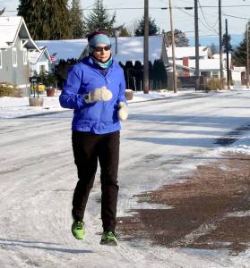 Katherine Hennessy of Port Angeles goes out for a morning jog on Cedar Street on upper Pine hill in Port Angeles on Tuesday. She said the cold and snowy weather doesnt deter her from training for future distance runs. (Dave Logan/for Peninsula Daily News)
