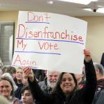 Several signs were brought into the packed Kitsap County courtroom on Tuesday. (Elisha Meyer/Kitsap News Group)