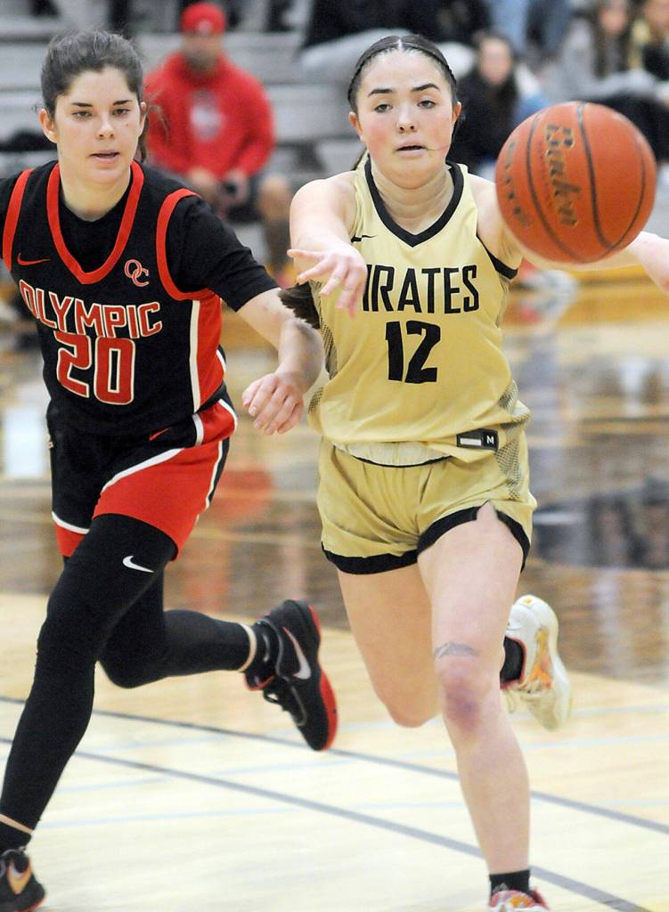 Peninsulas Hannah Bates, right, makes a running pass pursued by Olympics Marina Spitzer on Saturday at Peninsula College. (Keith Thorpe/Peninsula Daily News)