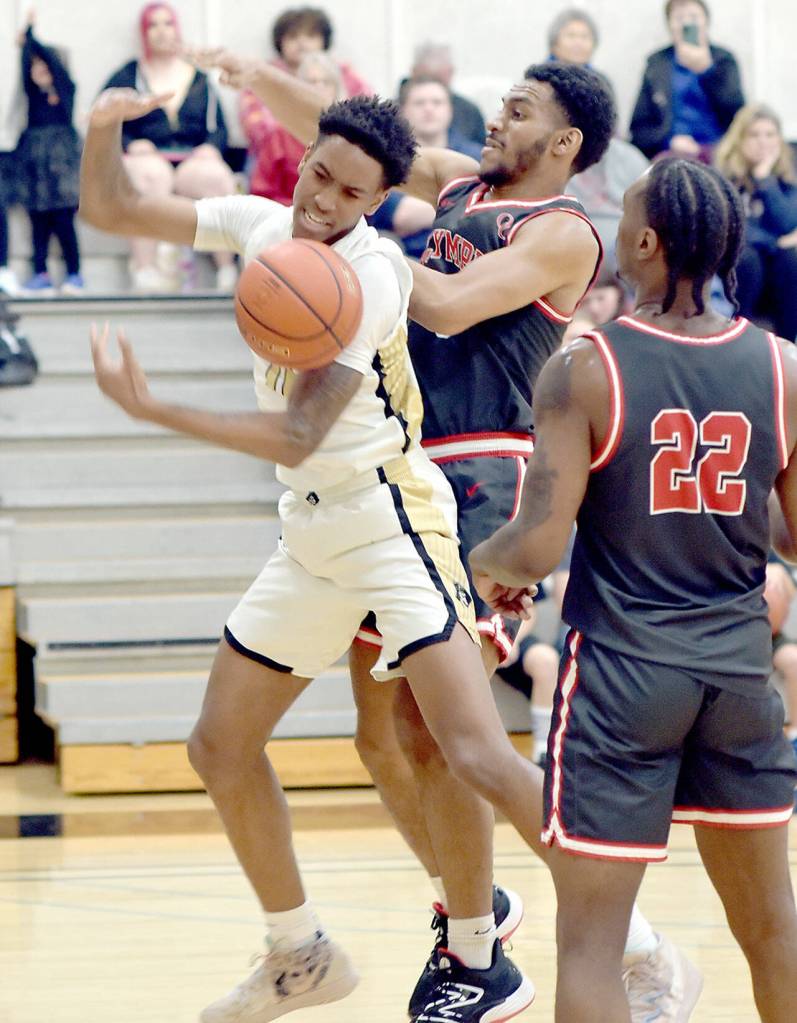 Peninsulas Antonio Odum, left, fights for a rebound with Olympics Asi Holmes as Lenz Dupont looks on during Saturdays game at Peninsula College. (Keith Thorpe/Peninsula Daily News)