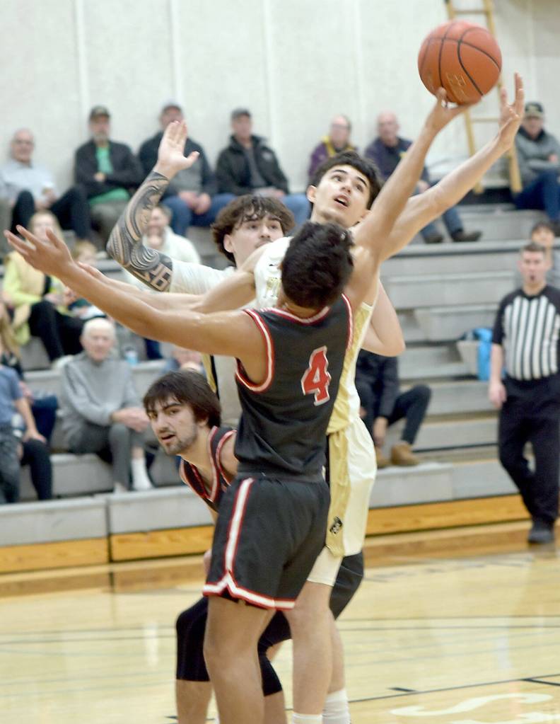 KEITH THORPE/PENINSULA DAILY NEWS 
Peninsula's Victor Meza, center, battles for a rebound with Olympic's Payton Davis as Meza's teammate, Aiden Olmstead, rear, and Olympic's Christian Parrish, bottom, poke out of the fray on Saturday in Port Angeles.