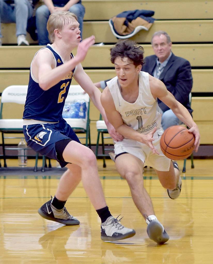 KEITH THORPE/PENINSULA DAILY NEWS Port Angeles Kason Albaugh, right, slips around Bainbridges Calum McCarter during Thursdays game on the Roughrider home court.