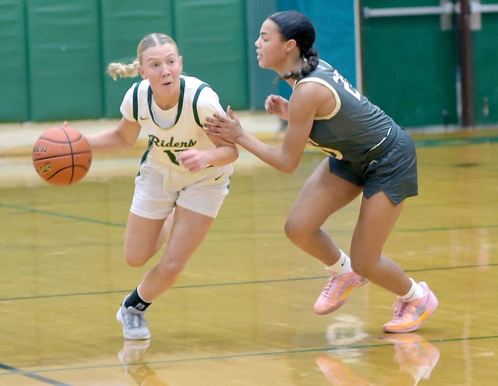 Port Angeles Izzy Felton, left, drives downcourt pursued by North Kitsaps Coriana McMillian on Tuesday night in Port Angeles. (Keith Thorpe/Peninsula Daily News)