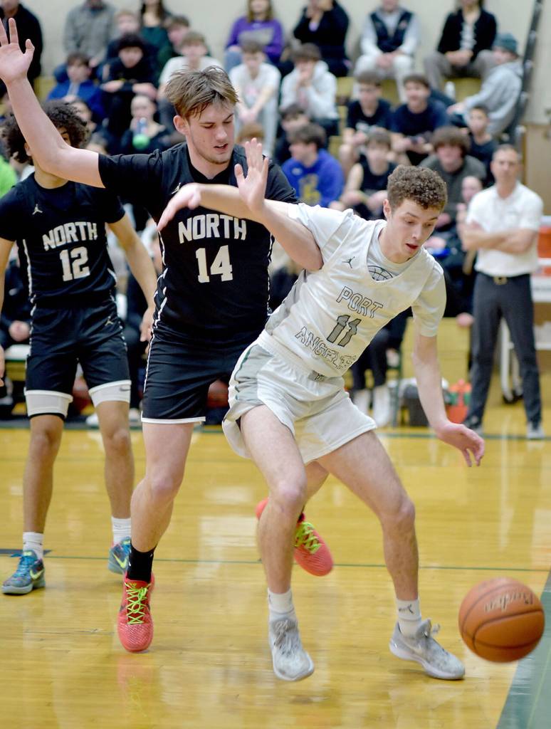 Port Angeles Dallas Dunning, right, watches a ball drift out of bounds as North Kitsaps Logan Hudson defends the lane on Tuesday at Port Angeles High School. (Keith Thorpe/Peninsula Daily News)