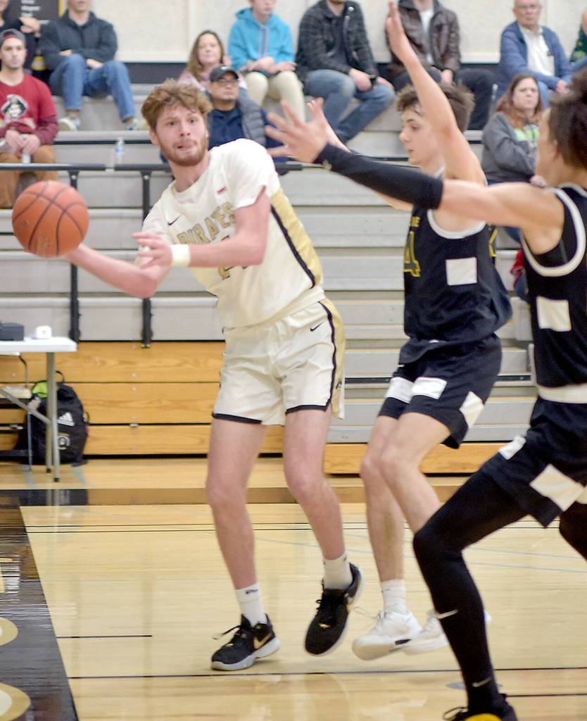 Peninsulas Wyat Dunning, left, passes down the baseline as Shorelines Isaiah Little and Joel Amaro, right, provide interference on Wednesday at Peninsula College. (Keith Thorpe/Peninsula Daily News)
