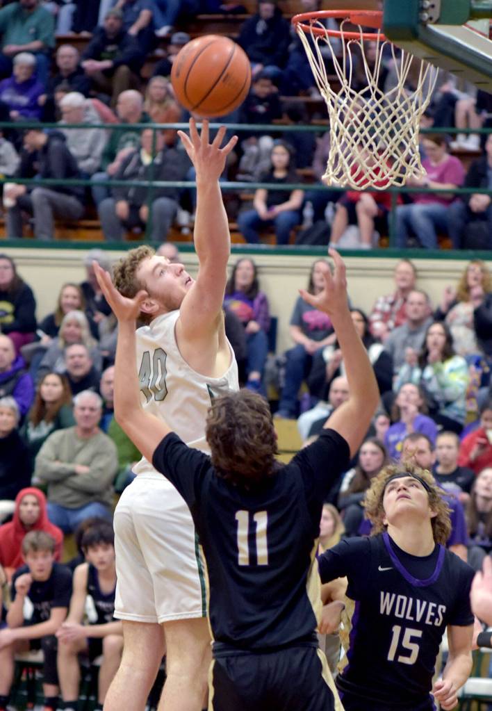 KEITH THORPE/PENINSULA DAILY NEWS Port Angeles Isaiah Shamp, left, goes for the goal over Sequims Charlie Grider, center, and Zeke Schmadeke on Tuesday night at Port Angeles High School.