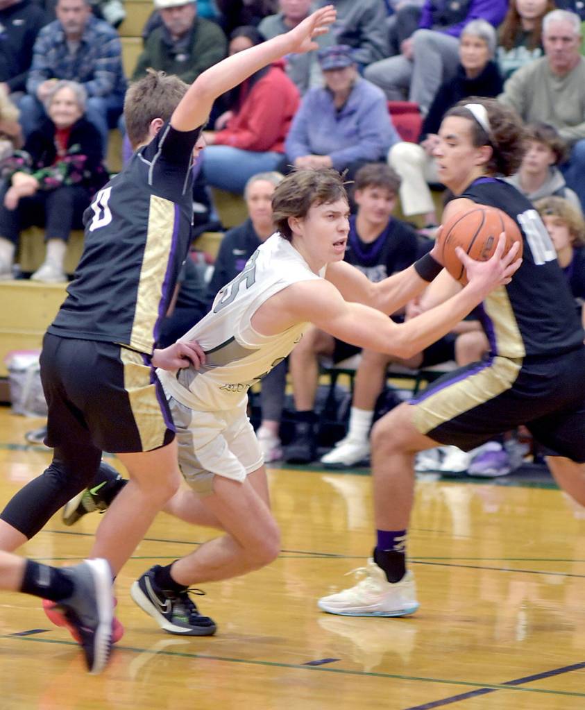 KEITH THORPE/PENINSULA DAILY NEWS 
Port Angeles' Parker Nickerson, center, pushes between Sequim's Ethan Melnick, left, and Lars Wiker on Tuesday night in Port Angeles.