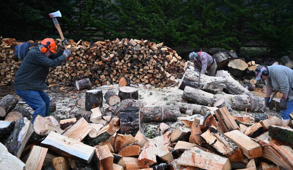 From left, Jack Tatom, Wally Jenkins and Dan Kalinski cut, chop and split wood for cords, whose sales go directly to help the Path From Poverty nonprofit. (Michael Dashiell/Olympic Peninsula News Group)