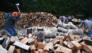 From left, Jack Tatom, Wally Jenkins and Dan Kalinski cut, chop and split wood for cords, whose sales go directly to help the Path From Poverty nonprofit. (Michael Dashiell/Olympic Peninsula News Group)