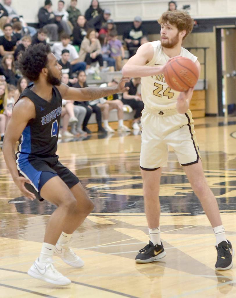 KEITH THORPE/PENINSULA DAILY NEWS 
Peninsula's Wyatt Dunning, right, looks to pass around Edmonds' Naser Motley on Saturday evening at Peninsula College.