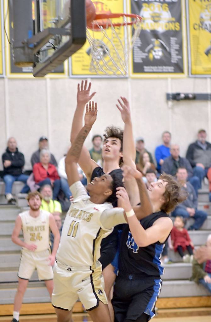 KEITH THORPE/PENINSULA DAILY NEWS 
Peninsula's Antonio Odum, front, and Edmonds' Jack Sims and Jaden Messer, right, watch as a ball gets wedged between the rim and the backboard, forcing a jump ball on Saturday in Port Angeles.