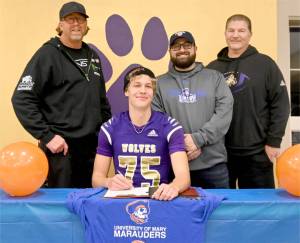 Sequims Jack Henninger signs a letter of intent to play football at the University of Mary (North Dakota). The all-Olympic League kicker plans to study occupational therapy and kick for the Marauders football squad. Behind him are, from left, soccer coach David Breckenridge, football special teams coach Cody Buckmaster and football head coach Erik Wiker. (Michael Dashiell/Olympic Peninsula News Group)