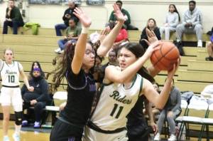 Port Angeles Lindsay Smith is surrounded by Foster defenders Wednesday night in Port Angeles in a bi-district playoff game. She scored 17 points as the Roughriders won 67-37 to qualify for the state 2A tournament. (Dave Logan/for Peninsula Daily News)