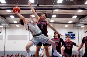 Lummi guard Jerome Toby gets fouled by Neah Bays Jodell Wimberly as he tries to shoot in the tridistrict championship game Saturday. (Finn Wendt/Cascadia Daily News)