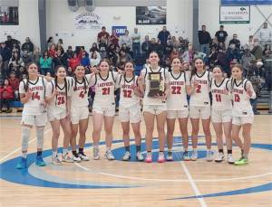 The defending state champion Neah Bay girls basketball team celebrates its tridistrict championship Saturday in Mount Vernon. (Courtesy photo)