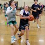 The Presidents Day Tournament sponsored by Ruddell Auto held in Port Angeles on Saturday and Sunday featured fourth- through eighth-grade teams, some of which came from as far away as Mount Vernon and Blaine. A total of 30 teams played in the tournament held at Port Angeles High School and Roosevelt Elementary. Here, Sequim seventh-grader #10 Aayden Soiseth (10) drives to the basket guarded by Port Angeless sixth-grade team member Payton Strohauer (21). Sequim won the game 35-23. The top two finishers in each division qualified for the Washington State Middle School Basketball Championship to be held in Spokane in March. (Dave Logan/for Peninsula Daily News)