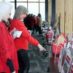 Mother and daughter Shelly Tweter and Peach Thompson look over silent auction items at the Red, Set, Go! event Friday at Field Arts & Events Hall in Port Angeles. (Dave Logan/for Peninsula Daily News)
