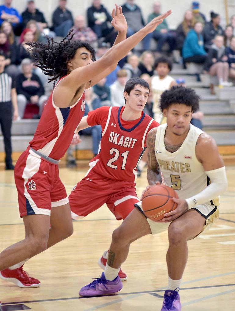 Peninsulas Jason Ervin, right, is held off by Skagit Valleys Sylas Williams, left, and Connor Drinkwine on Wednesday night in Port Angeles. (Keith Thorpe/Peninsula Daily News)