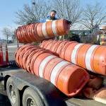 KEITH THORPE/PENINSULA DAILY NEWS
Chris Johnson of Nordland-based Nordland Construction loads traffic drums onto a trailer as coworker Robert Bufford prepares to secure the load as the pair prepares to open the parking lot at Port Angeles City Pier to automobiles on Friday. The work was part of a project to improve storm drainage, replace damaged sidewalks and ADA ramps and mitigate shoreline erosion around the lot, which had been closed since early January. Tree replacement and other project detail work is expected to follow over the next few weeks.
