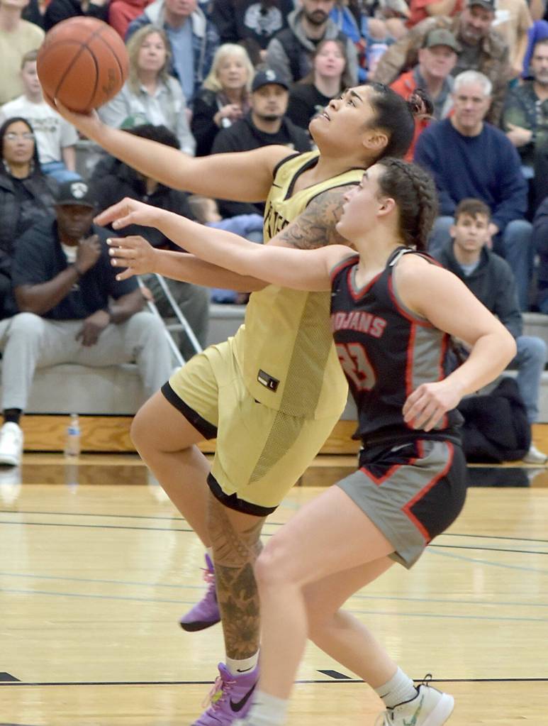 KEITH THORPE/PENINSULA DAILY NEWS Peninsulas Ciera Agasiva, left, aims for the rim pursued by Everetts Jada Andresen on Saturday in Port Angeles.