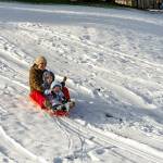 Lena Curtis guides a snow sled with her two children, Lucien Williams, 4 1/2, and Millie, 2, all from Port Townsend, down a snow hill at Port Townsend High School on Tuesday. An overnight storm passed through but not before depositing about 3 inches of soft powder, which melted rapidly as the day warmed. The blast of snowfall was largely confined to the area around Port Townsend and Port Hadlock overnight into Tuesday morning on the North Olympic Peninsula. Another weather system was coming in on Tuesday afternoon and is expected to drop rain in the lowlands and snow in the mountains on Wednesday and early Thursday, according to meteorologist Jacob DeFlitch with the National Weather Service in Seattle. (Steve Mullensky/for Peninsula Daily News)