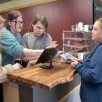 KEITH THORPE/PENINSULA DAILY NEWS
Coffee customer Lauren Wright of Port Angeles, right, gets assistance at the counter from Career and Technical Education program students, from left, Jordis Vance, 17, Rayin Blewett, 18, and Maple Romberg, 16, on Friday's opening day of the Wildcat Cafe at Lincoln Center in Port Angeles.