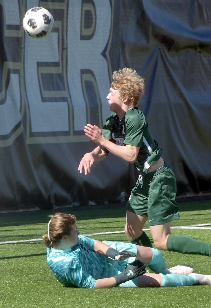 KEITH THORPE/PENINSULA DAILY NEWS Port Angeles Matthew Miller trips over Klahowya goalkeeper Rezyn Moore in a charge to the net on Saturday afternoon in Port Angeles.
