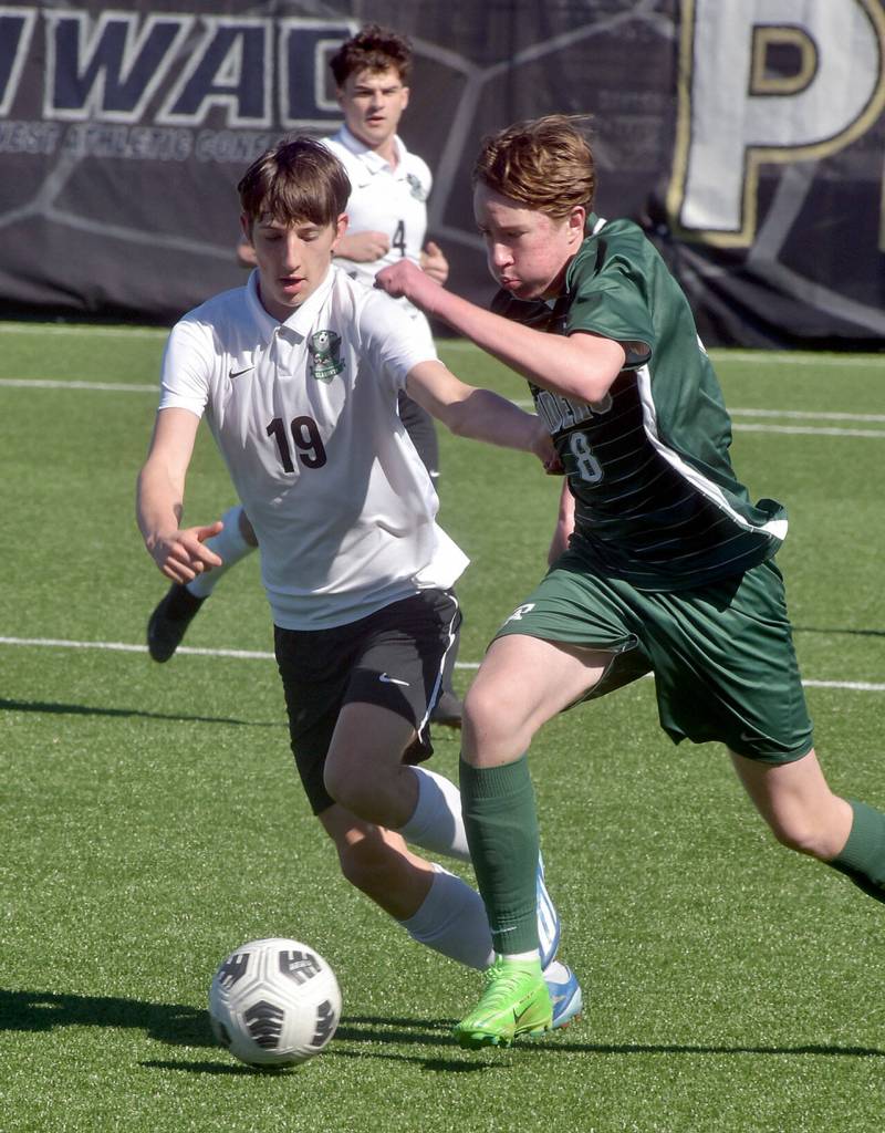 KEITH THORPE/PENINSULA DAILY NEWS Port Angeles Jacob Weaver, right, dribbles past Klahowyas Elijah Body as Klahowyas Oliver Peterson follows behind on Saturday at Peninsula College.