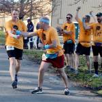 Chris Hartman of the Olympic Peninsula Frosty Moss relay team Sub Alpine Tees passes the relay stick off to teammate Chris Cummings as the rest of Sub Alpine team members cheer him on. Sub Alpine Tees was one of 61 relay teams to compete. (Dave Logan/for Peninsula Daily News)