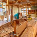 Joel Arrington, boat shop manager for the Northwest Maritime Center, looks at the bow of a boat he cut in half that will be an exhibit piece in the new Welcome Center being constructed in what was formerly the retail shop. The new space will have a smaller retail space with the rest of the floorplan devoted to exhibits. (Steve Mullensky/for Peninsula Daily News)
