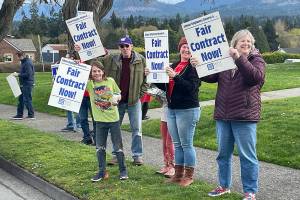 Supporters of paraeducators rally outside the Port Angeles School District administration headquarters at Lincoln Center on Thursday. The Port Angeles Paraeducators Association has voted to strike April 8 if an agreement with the PASD for a 3.7 percent wage increase can't be reached. (Paula Hunt/Peninsula Daily News)
