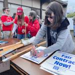 Becca Paul, right, helps assemble signs for the Port Angeles Paraeducators Association strike on Monday. Paul, a paraeducator at Jefferson Elementary School, is among 130 union members who will walk off their jobs in the Port Angeles School District as they call for a 3.7 percent wage increase, better longevity increases, enhanced salary steps and recognition for certification and academic degrees. (Paula Hunt/Peninsula Daily News)