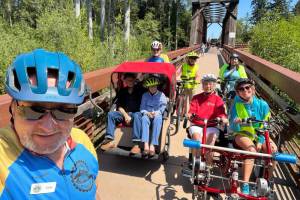 Sequim Wheelers, seen on the historic Railroad Bridge near the Dungeness River Nature Center, prep for a ride on the Olympic Discovery Trail. The nonprofit's season begins in May, and it has an open house for potential new volunteers on April 20 at the River Center. It also has an orientation for new volunteers on April 25 at the River Center. (Sequim Wheelers)
