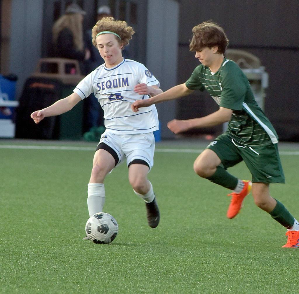 KEITH THORPE/PENINSULA DAILY NEWS Sequims Max Stanford, left, dribbeles past Port Angeles Aurelio Wilson-Rojero on Tuesday in Port Angeles.