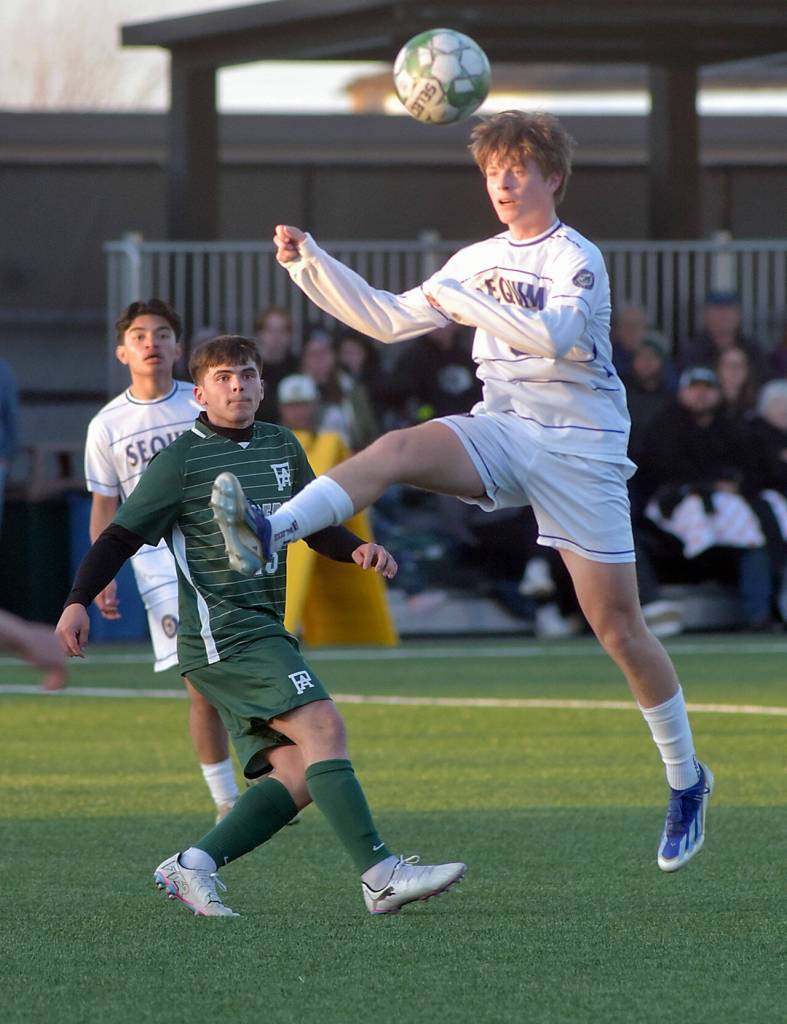 KEITH THORPE/PENINSULA DAILY NEWS Sequims Finn Braaten, front, takes a header as Port Angeles A.J. Martinez keeps watch on Thursday at Peninsula College.