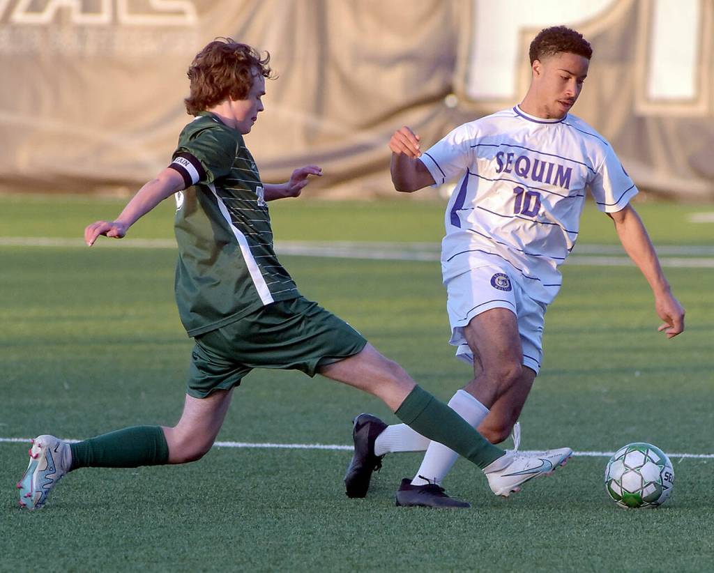 KEITH THORPE/PENINSULA DAILY NEWS Sequims Mekhi Ashby, right, fends off Port Angeles Grant Butterworth on Tuesday evening at Peninsula College.