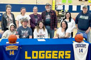 Crescents Ciara Cargo-Acosta, center, signs to play basketball for Northwest Indian College. She is flanked by parents Jeremy Acosta and Vashti White-Acosta. (Courtesy photo)