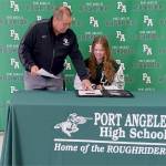 Port Angeles Athletic Director Dwayne Johnson presents Dachs with her letter of intent for The Evergreen State College. (Pierre LaBossiere/Peninsula Daily News)
