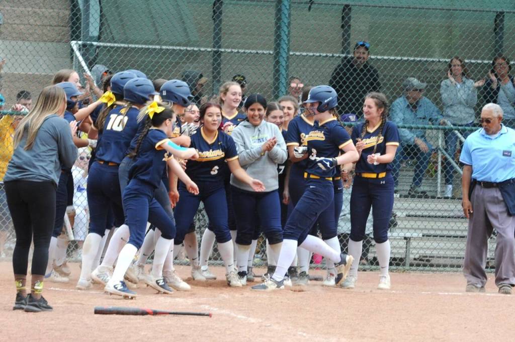 The Forks Spartans softball players greet teammate Keira Johnson (No. 3) as she arrives home after hitting a home run Friday against Warden. (Lonnie Archibald/for Peninsula Daily News)