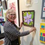 Liisa Fagerlund with a bead-embellished floral image on display at the A. Milligan Gallery on North Sequim Avenue.