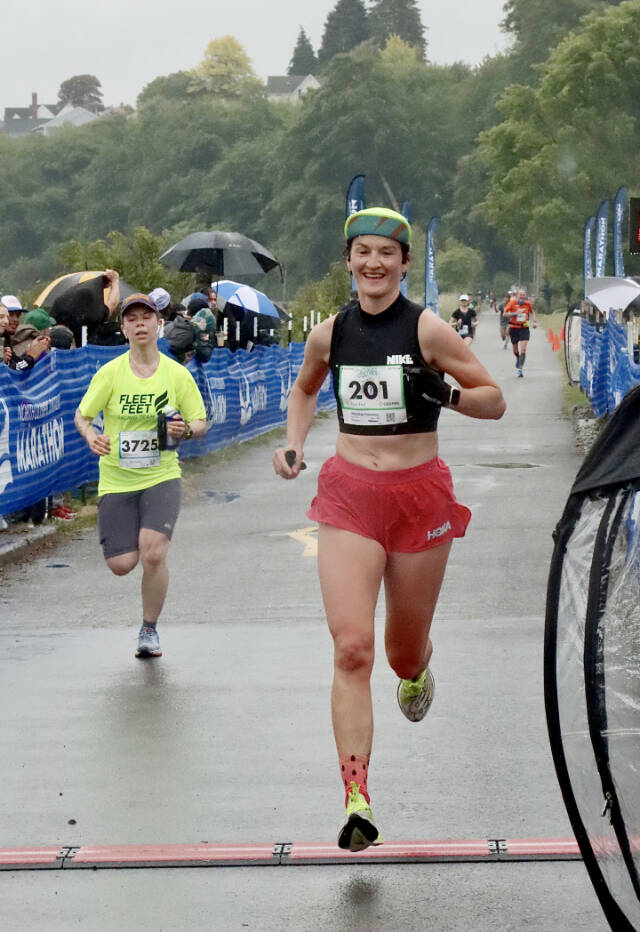 Natasha Parsons of Nanaimo, B.C., right, wins the womens marathon in the NODM marathon Sunday morning. Wet weather and a lack of wind made for fast times as Parsons won in 3:01:5.31. (Dave Logan/for Peninsula Daily News)