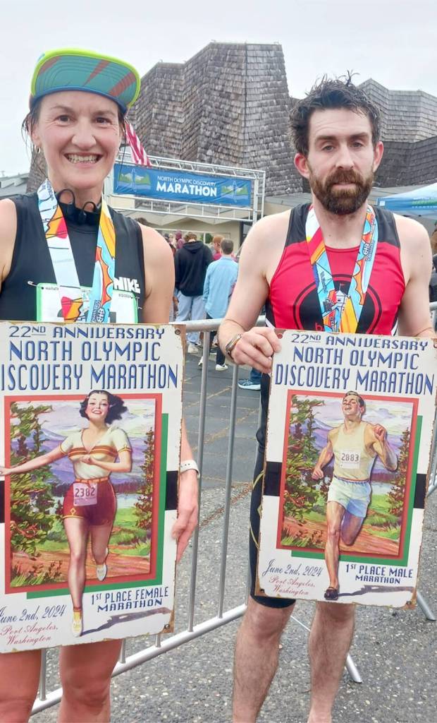Marathon winners Derek Binnersley and Natasha Parsons, both of Nanaimo, B.C., with their first-place posters after the North Olympic Discovery Marathon. (Pierre LaBossiere/Peninsula Daily News)