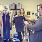 Alicia Scofield, left, and Summer Cooper, family navigators for the Port Angeles School District, sort over donated clothing available to students and their families at the Caring for Kids Clothing Closet located at Lincoln Center. (Keith Thorpe/Peninsula Daily News)
