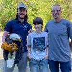 Joseph Molotsky of Discovery Bay Wild Bird Rescue, left, holds an eagle that Annie Espinoza, center, rescued with her friend Kate Burks last month near McDonald Creek. Her uncle, Daniel McMurray, right, drove her to the rescue center the next morning so the bird could be treated. It continues to be treated for a possible hip and/or spinal injury. (Dungeness Bay Wild Bird Rescue)