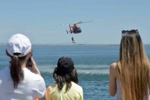 Spectators watch a U.S. Coast Guard rescue drill in Port Angeles Harbor during Saturdays Maritime Festival along the Port Angeles waterfront. The two-day event, hosted by the Port of Port Angeles, served as a showcase for boating and the maritime trades. (Keith Thorpe/Peninsula Daily News)